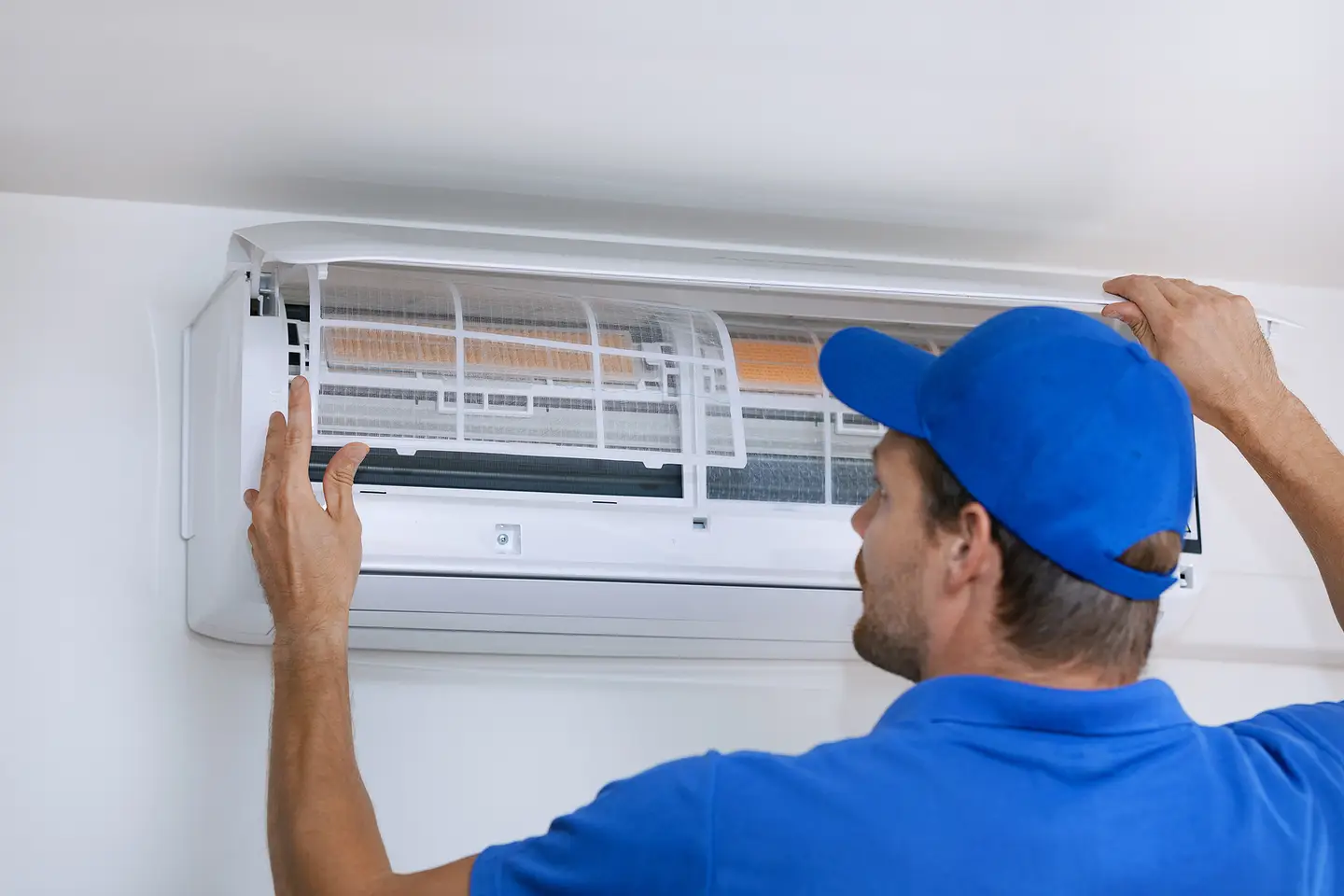 An Hvac Technician Working On A Ductless System In Ogden, Ut An Hvac Technician Working On A Ductless System In Ogden, Ut