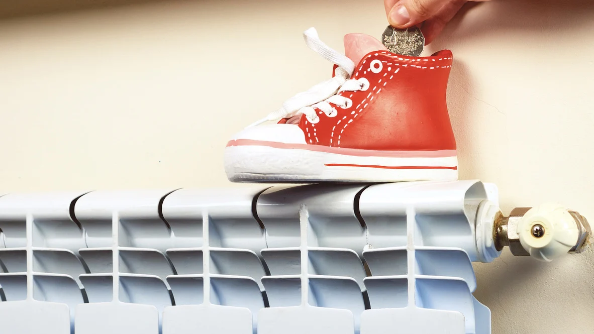 HVAC Financing – Ogden, UT – Absolute Comfort Ogden customer puts money in little shoe on radiator to save for better HVAC system