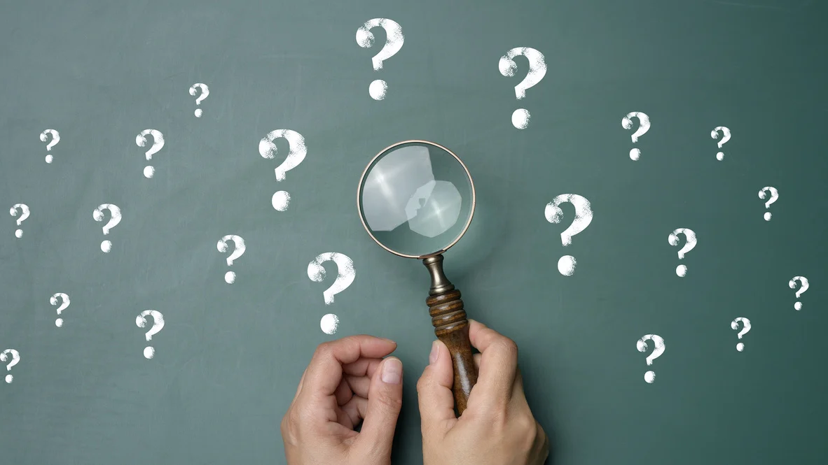 Heat Pump FAQs – Ogden, UT – Absolute Comfort Chalkboard with drawn question marks and hand with magnifying glass