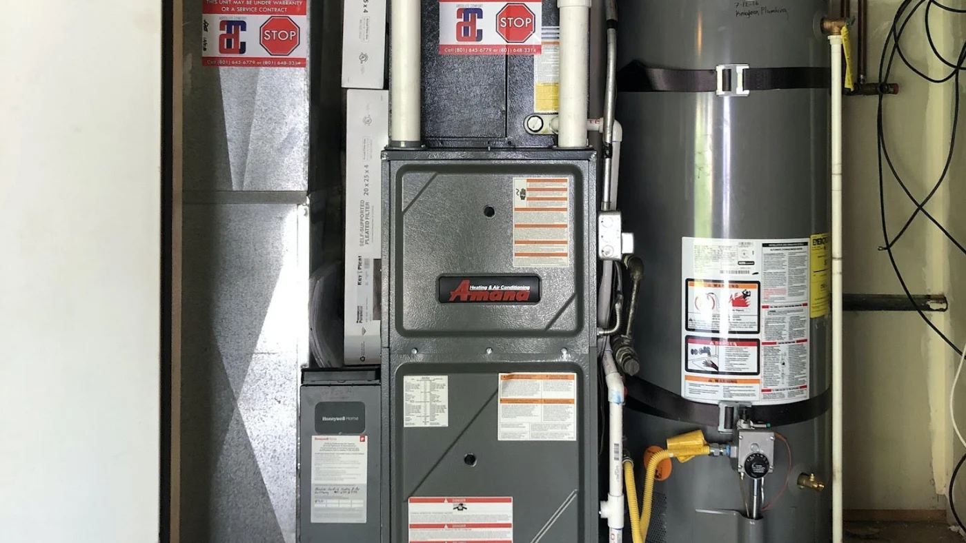 HVAC Products – Absolute Comfort – Ogden, Utah Happy Absolute Comfort Heating & Air Conditioning customer adjusts thermostat in Ogden, UT home